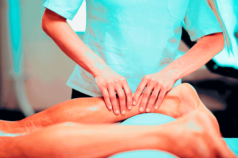 Symbolbild einer manuellen Therapie, eine Person therapiert das Bein